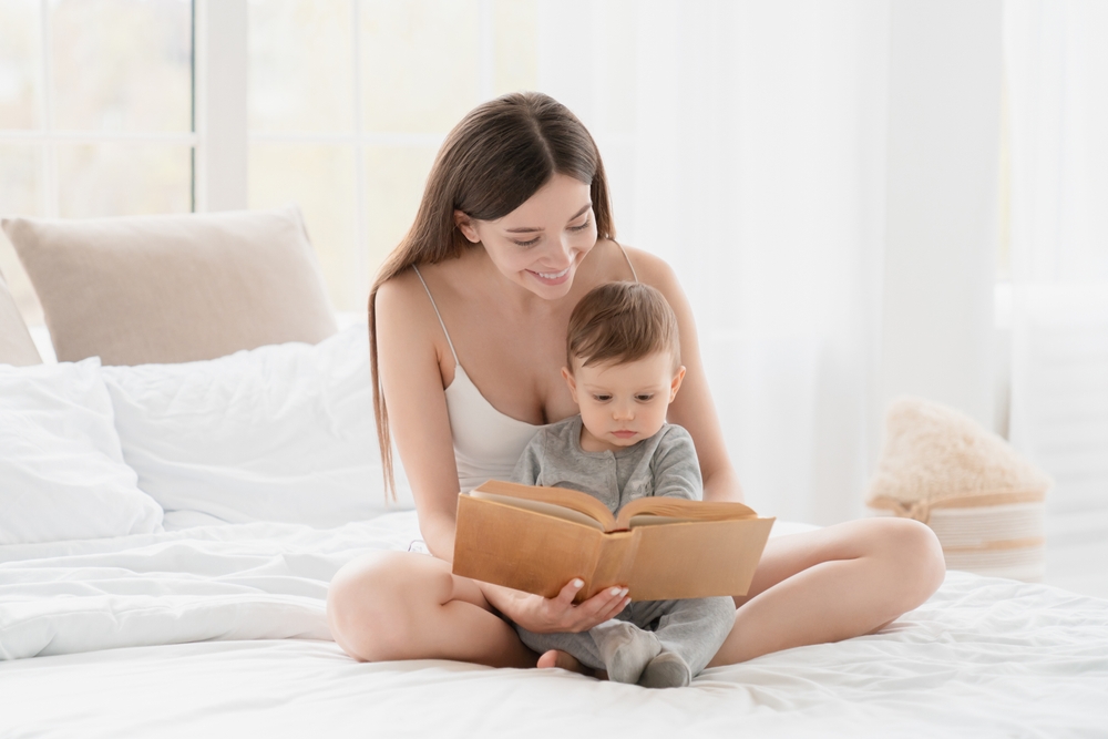 Young,Mother,Reading,A,Book,Of,Fairytales,With,Her,Child